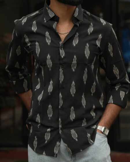 Close-up of the collar, button front and ivory ikat motifs of a model wearing the Black Single Ikat Shirt.