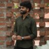 Angled view of a model wearing the Olive Slub Cotton Shirt.